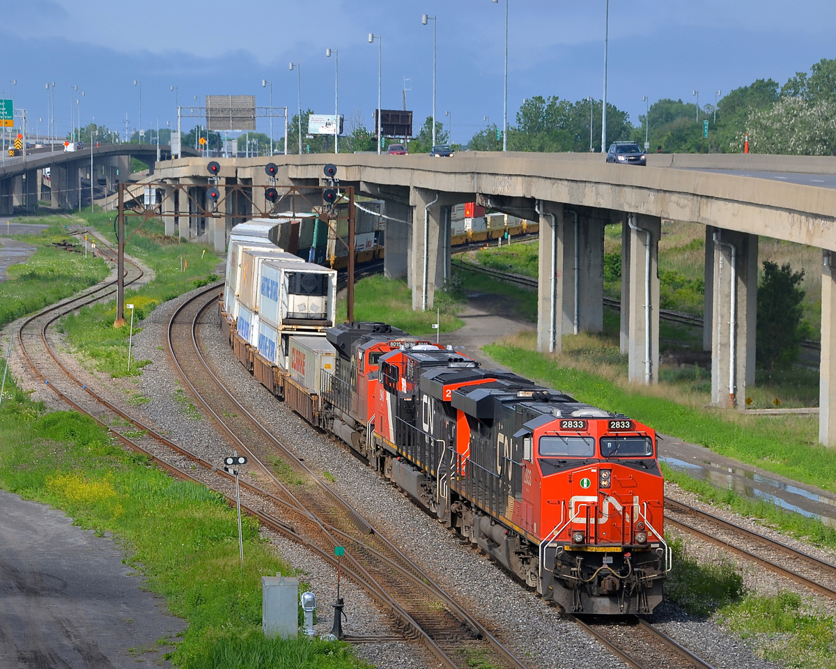 A long CN 120 (610 axles) has older ES44AC CN 2833 and newer ES44AC CN 2940, along with SD70M-2 CN 8015 as it heads east through Turcot West.