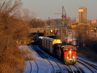 <b>Under a soon to be demolished tunnel.</b> CN 401 is exiting from a tunnel that will be demolished shortly as part of infrastructure projects in the area with CN 2909 leading. It's about 25 minutes before sunset and the lead unit is bathed in some great winter light.