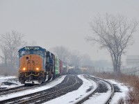 <b>Faded CSX lettering in the snow.</b> With light snow falling, SD70MAC CSXT 4797 with faded CSX lettering on the nose leads CN 327 through Dorval.