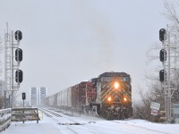 <b>Coming off a bridge in the snow.</b> A longer than usual CP 253 (118 cars) is coming off the CP bridge over the St-Lawrence river with CEFX 1039 & CP 7305 as power as some now falls on the first day of 2016.