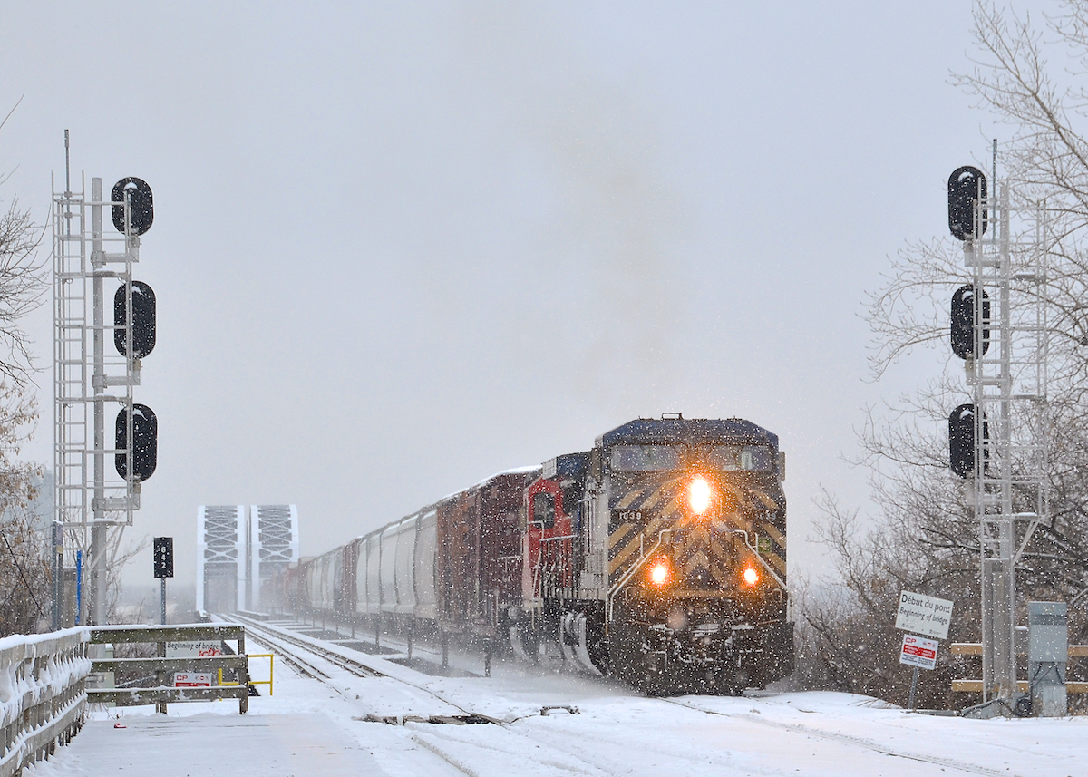 Coming off a bridge in the snow. A longer than usual CP 253 (118 cars) is coming off the CP bridge over the St-Lawrence river with CEFX 1039 & CP 7305 as power as some now falls on the first day of 2016.