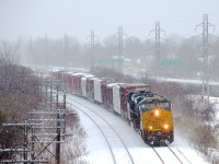 <b>CN 327 around the corner.</b> A pair of Boxcar logo ES44AH's (CSXT 3144 & CSXT 3002) lead CN 327 through Beaconsfield on a snowy afternoon with 69 cars in tow.