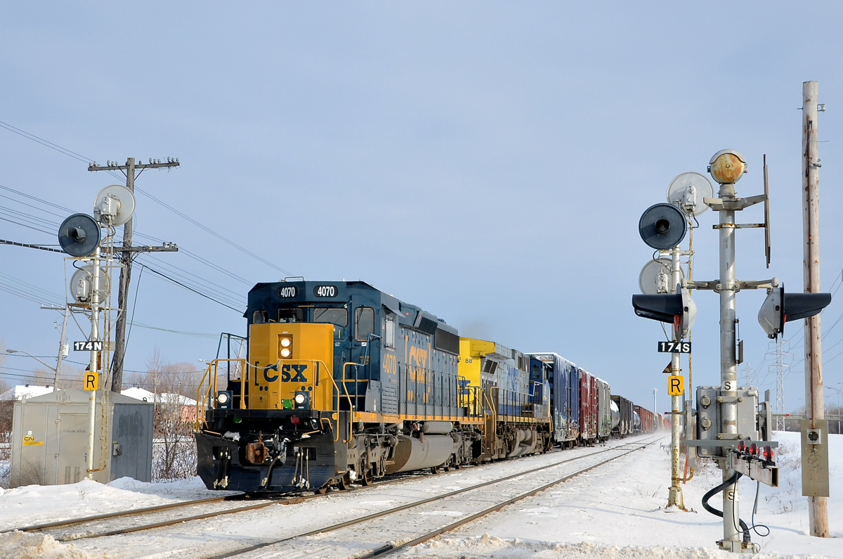 A SpongeBob Squarecab splitting the signals. CN 327 with rebuild SD40-3 CSXT 4070 leading (dubbed 'SpongeBob Squarecabs' by railfans) and CSXT 88 trailing splits the signals on CN's Kingston sub at the Woodland crossing in Beaconsfield.