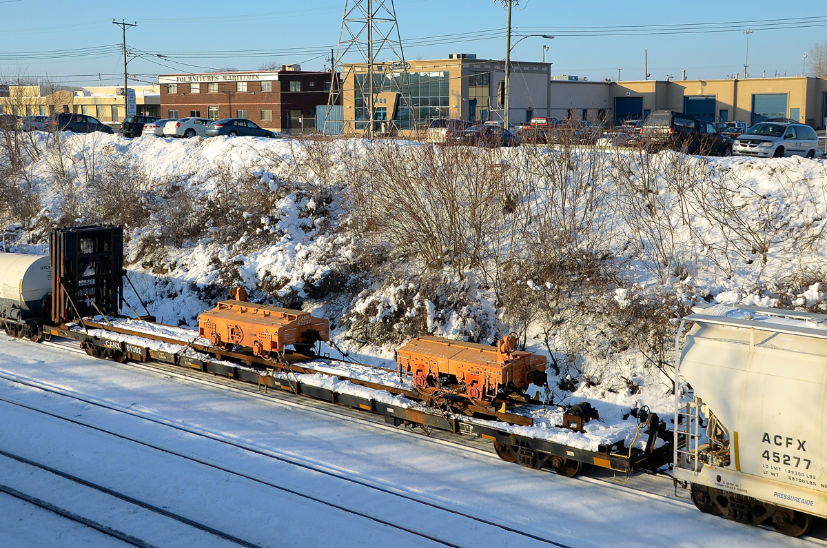 Scale test cars. CN 527 is heading to Taschereau Yard with two Canac scale test cars in tow on a flatcar (CANX 52257 & CANX 52104 on flatcar CANX 61302).