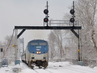<b>Winter wonderland.</b> AMTK 202 leads the southbound Adirondack towards its station stop at St-Lambert. Sticky snow is covering the trees all around.