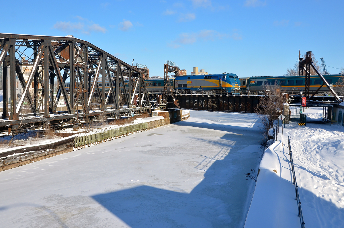 Meet over the canal. VIA 912 pushes a deadhead movement towards Central Station over the Lachine canal as VIA 55 is Toronto-bound on the north track.