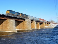 <b>A clean repaint leading.</b> Repainted AC4400CW CSXT 312 is leading CN 327 over the Ottawa River as it leaves the island of Montreal. Trailing is C40-8 CSXT 7619.