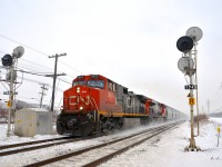 <b>A friendly wave from the conductor.</b> CN 377 kicks up the snow as it speeds through Beaconsfield with CN 2633 & CN 2262 for power, as the conductor waves.