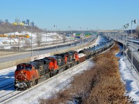 <b>A late-running CN 305.</b> A later than usual CN 305 is slowly approaching Turcot West in Montreal where it will get a new crew. Power is CN 2343, a very clean CN 2116, CN 2258 and DPU IC 2711. CN 2116 & CN 2258 are just along for the ride, as both are on idle. In the background at left is the skyline of downtown Montreal.