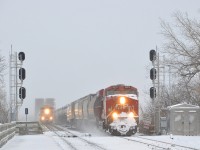 <b>CP wins the race over the river.</b> CP 253 with snow-covered CP 8912 as sole power has won the race to the island of Montreal as it crosses the St-Lawrence river, with AMT 74 at left not too far behind with F59PH AMT 1342 as power on a windy and frigid morning.
