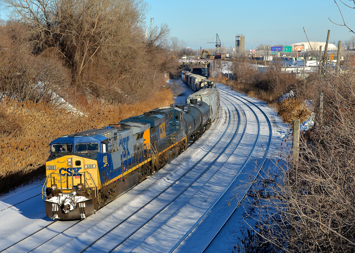 CSXT power on CN 393. CN 393 is returning from Richmond, Qc and interchange with the St. Lawrence and Atlantic Railroad with two CSXT GE's for power (CSXT 488 & CSXT 837) on a sunny but still cold afternoon. Normally CN 393 would return to Montreal in the middle of the night, but the crew had run out of hours in Richmond yesterday.