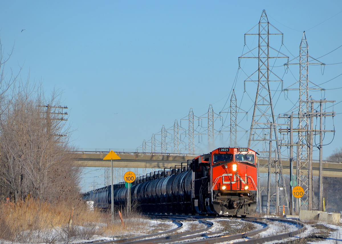 Past the LRC speed limit signs. CN 377 with CN 2621 leading is rounding a curve in Sainte-Anne-de-Bellevue, passing speed limit signs for VIA Rail trains having LRC consists in the process.