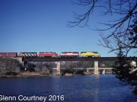 A multi-coloured locomotive consist leads GEXR 432 across the Grand River from Kitchener to Breslau enroute to MacMillan Yard. 