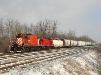 Guelph Junction Railway 1591 (GMD GP9u) along with OSR 1210 (GMD SW1200RSu) are switching hopper cars and tank cars at Guelph Junction as they approach the First Line with a band of snow clouds approaching.