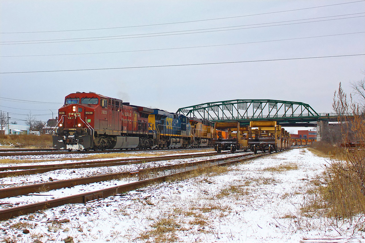 The first ordered CP 143 of 2016 has a pretty decent lashup with CP 9639, CSX 5464 and UP 5545. 143 is a little later than usual, and is often through Fort Erie by 9am. 


A lot has changed in Fort Erie in the past couple of years, and the biggest change has yet to come. Last year CN consolidated most yard operations from Fort Erie to Port Robinson, making this yard quite dead, and void of any CN power. The yard has been used for storage since then (much like Niagara Falls was before being torn up). With rail traffic quite slow recently due to a 'technical' recession, the yard is crammed full, with unique twin stack well cars making up the mix at the east end of the yard. The twin stacks were among the first well cars to accommodate double stack intermodal, and their technology is now redundant. 


Fort Erie is about to lose one of Niagara's more iconic bridges, the Central Avenue bridge in the background. The handrails on the east side of the bridge are already being dismantled, and the entire bridge will be replaced by the end of the summer. The truss structure is expected to come down sometime in April or May, ending its 63 year history. Until then, get your shots, as a few months goes by quickly.