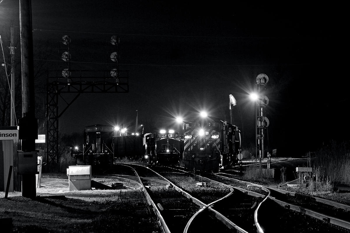 Nineteen years ago, Port Robinson was a relatively lightly used yard that saw a yard job that either went to Thorold South or the chemical plants at the very west end of Niagara Falls. There was also a local that went to Merritton on the Thorold Sub, which was also used by most westbound freights, until Welland Canal bridge 10 was knocked down in mid 1997. Until seven years ago, Port Robinson was still lightly used, however, the economic collapse of 2008, changes in railroad methodologies, and further economic struggles have jammed this yard to capacity. It began with CN 330 and 331 starting and ending at Port Robinson. Before, that location was Fort Erie, until they were briefly cancelled during the recession. Then they returned, and CN 338 and 339 were slashed only a month afterwards, leaving no direct trains to and from Buffalo. CN 421 and 422 were promptly extended to Fort Erie. Around 2012-13, Niagara Falls Yard, which had been used as a storage yard since about 2007, was almost completely torn up. Niagara's manufacturing never really recovered from the 2008 recession, and in early 2015, the decision was made to close Fort Erie Yard for regular use, putting Port Robinson at complete capacity. Now CN 421 and 422 are back to Port Robinson. Port Robinson is a pretty poor railfanning location, despite the sprawling spurs and bustling yard action. Unless you have a quadcopter, the only shot you can really resort to is this one. However, the biggest pain incurred was on the train crews and trainmasters, who have to work around a yard that was not built for heavy activity. Fort Erie wasn't either, however it has much more space. Niagara Falls, which was built for heavy usage, interestingly, was the first yard to hit the chopping block, literally. It was also a very ideal railfanning location.


Today though, Port Robinson stands alone as CN 330 sits, with the leader BCOL 4617 occupying the main. CN 2805, on the far left, most likely was pulled off CN 421 the day before and served the Chemical Lead in west Niagara Falls recently, and quite possibly the Abitibi mill in Thorold South. As for the two GEVOs in the distance, I believe those were off the previous day's 330, and never left for some reason. Today's 330 had three units, BCOL 4617, CN 5735 and CN 2291 elephant style, and also had 95 cars. Both of those factors are quite uncommon, although there was a brief surge of traffic on this train back in early August, which saw three unit lashups of 90+ cars.