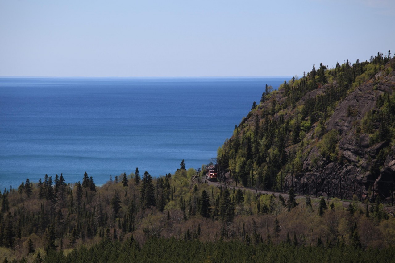 The first full day of my visit to Canada in 2015, June 5 started off miserable with the clouds hanging very low above Marathon on the north shore of Lake Superior. I was in for a very slow and cold start. While waiting for a train it seemed that the clouds were dispersing. So it happened. The first of two eastbounds arrived under a cover of clouds. After a meet with one westbound I was able to get the one shot I had been waiting for a number of years to take. The eastbound drag with 9657, 9360 and 3085 is seen rounding the bend before crossing the Little Pic River with the expanse of Lake Superior in the background.