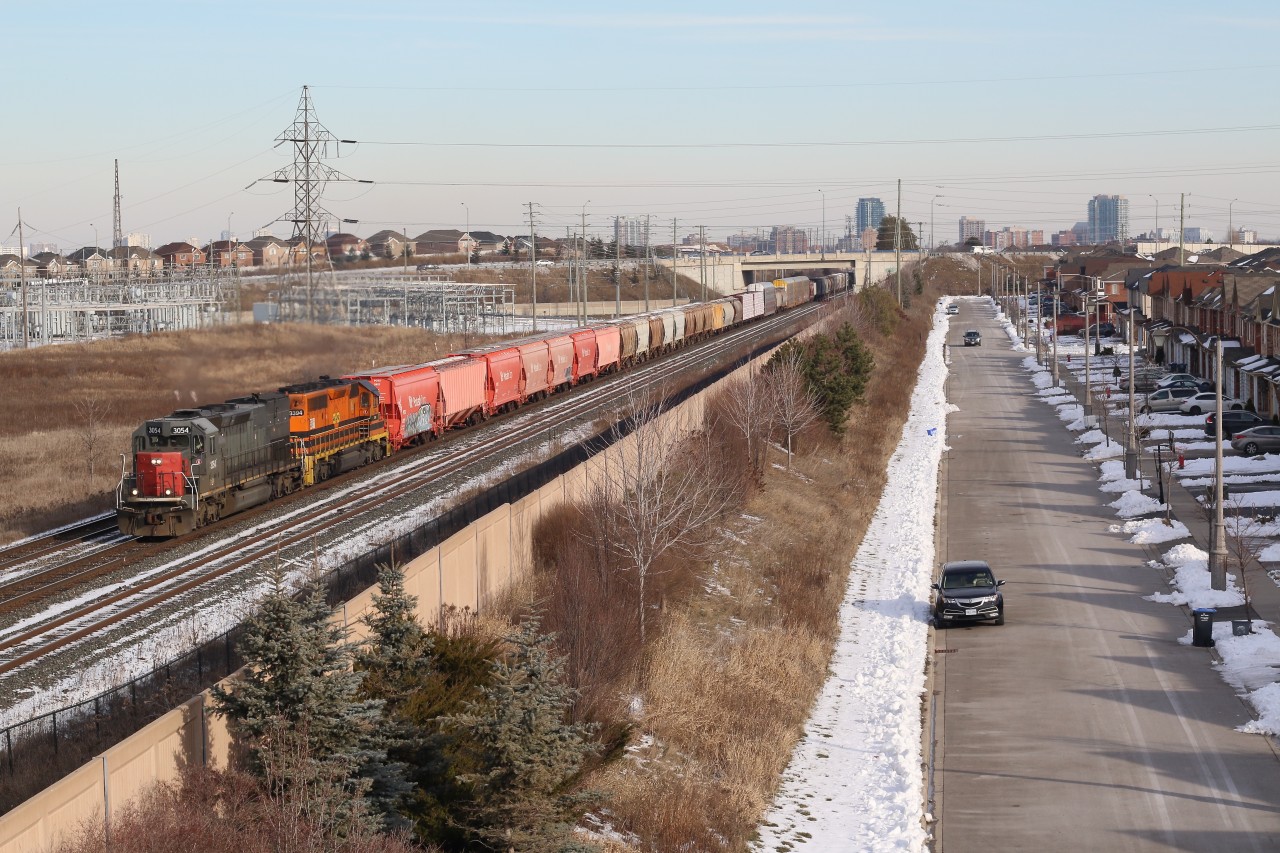 Goderich - Exeter train 431 is seen rolling past the Mount Pleasant transformer station and more recent urban sprawl in Brampton. The train is traveling over CN's Halton subdivision, and a lot has changed at this location over the past decade or so. The Halton sub. was previously double track, the Chinguacousy Rd bridge in the background was a level crossing, and the William's Parkway bridge I am standing on along with the residential development didn't exist. How times change.