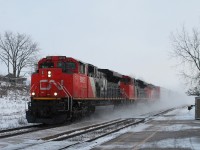 Westbound mixed freight with CN 8922,8023 and 5340 in charge race through the morning snow flurries kicking up a "track blizzard".