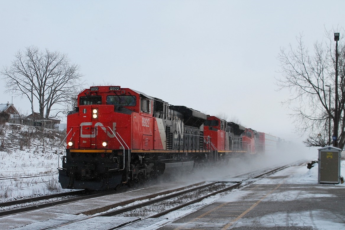 Westbound mixed freight with CN 8922,8023 and 5340 in charge race through the morning snow flurries kicking up a "track blizzard".