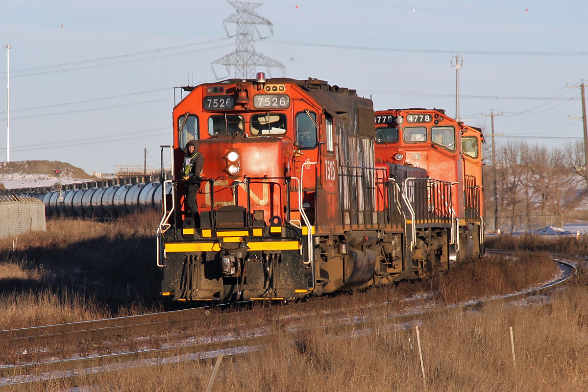 Having collected a good number of tank cars at Clover Bar GP38-2 CN 7526, followed by YBU-4m 526  and two more GP38's heads off towards Edmonton. Still being driven from the footplate with the remote pack although it is a chilly winters day.