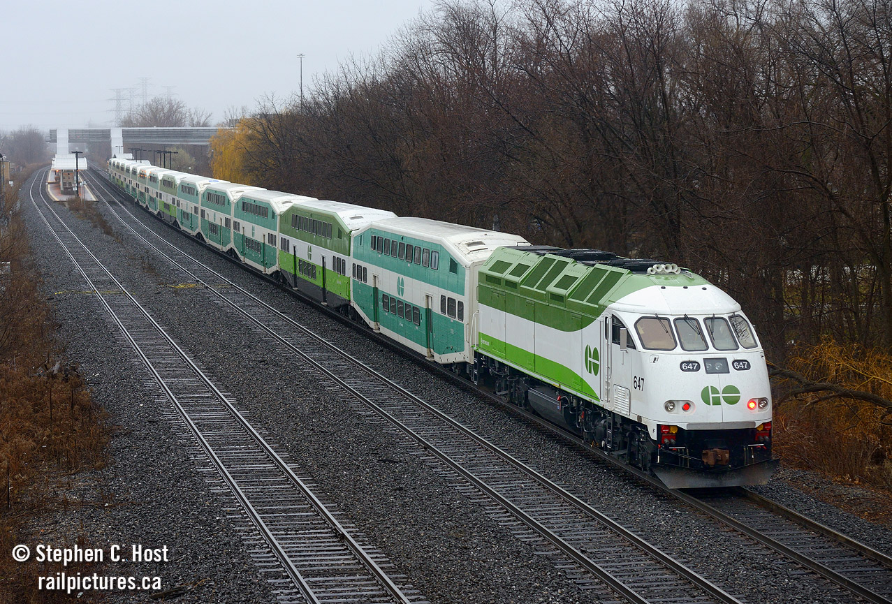 Do you like me? is what I imagine this engine would say in this photo. GO 647 is shown with a 14 car (!) GO train at Burlington Station, with the heavily modified GO 647 in the lead. First built in 2010 as a MP40PH-3C, 647 was sent back in 2013 to MPI for conversion to tier 4, which MPI calls the MP54AC. But it's probably not the same as a true MP54AC and is likely to be a one-off.
What was done? The EMD 710 engine was removed (Oh the horror!) two Cummins QSK60 engines have been installed (Total 5400 HP) the body heavily modified to allow for the extra exhaust stacks and air intake grilles, control systems modified.. a true MP54AC would also change the traction motors to AC but I have been informed this wasn't changed in this unit, which means this may be the only DC powered MP54 - would this be A MP54DC in this case? Either way, there are 17 or so more of these coming, but all will be built from the ground up instead of re-powered like the 647. It's yet to be seen if GO Transit will elect to bother with AC traction in the new models or continue with DC, surely like any locomotive these will simply be 'options'. 
This train was a GO break-in and testing run for 647, over this weekend they ran with the 14 car train set (2 extra cars to simulate a fully loaded train) at speeds up to 90-MPH, to assess braking, stopping distance, acceleration and station to station performance. The train also uncoupled half the train to test under lighter loading conditions or with shorter trains. Metrolinx would then surely decide if they indeed liked 647.. or not.. only time will tell what their decision is!
What did it sound like?.. to put it mildly... a truck. Quite underwhelming, but not unexpected. Personally, I don't care for it. 
So.. do you like this engine? What do you think? Comment below. P.S: This engine is likely to enter service this month if not already.