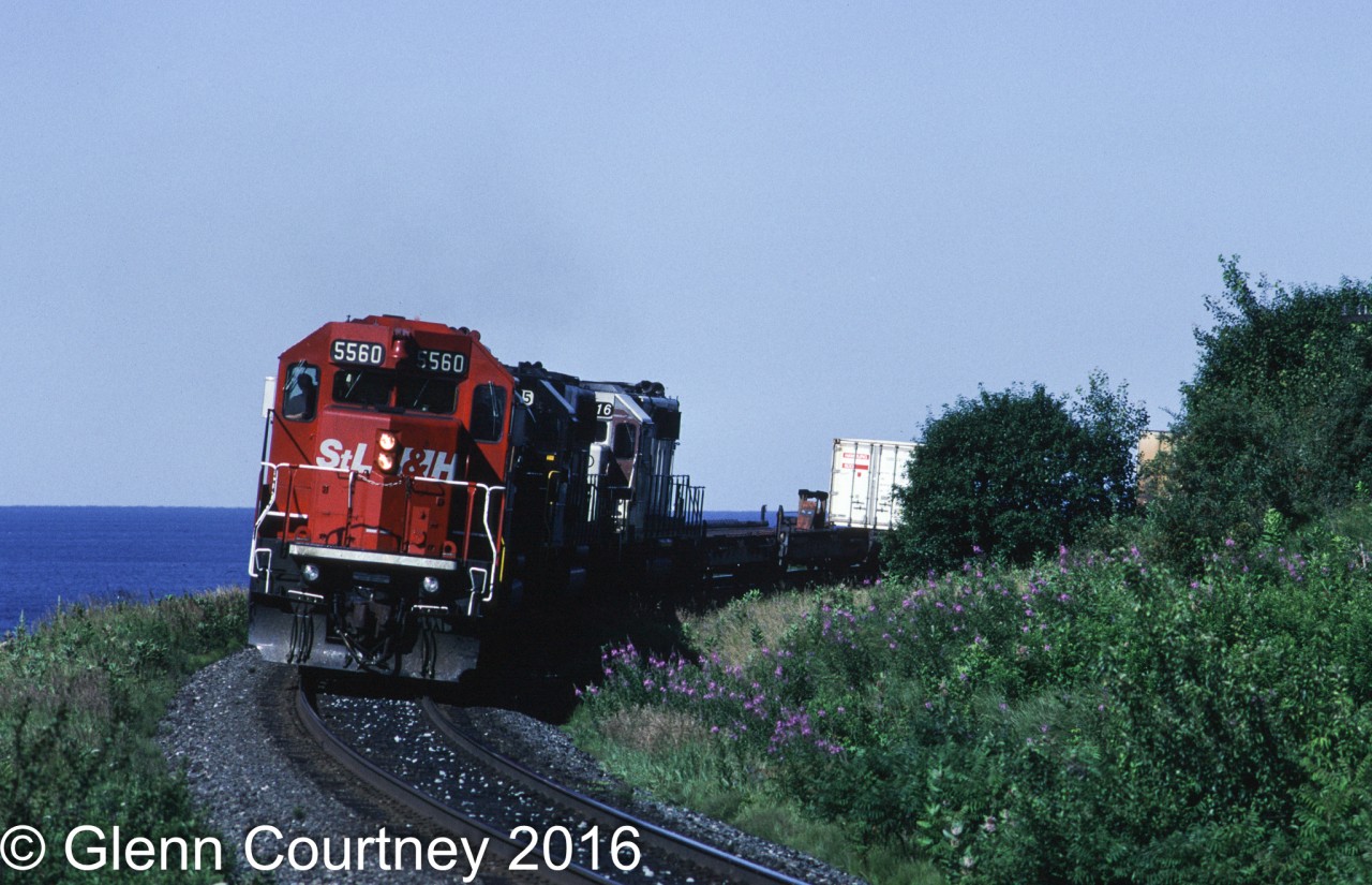 STLH SD40 5560 is leading CPR train #918 on the approach to Port Hope. Behind 5560 is a pair of Norfolk Southern units and CPR 5416 (a former KCS SD40-2 still wearing KCS white paint). Behind the train is Lake Ontario, CN's mainline is over the bank between the CPR and the lake.