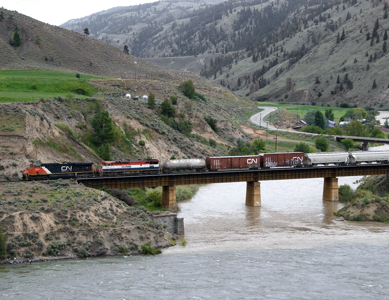 Eastbound CN mixed freight 416 using directional running on the CP crosses the Nicola River just east of Spences Bridge siding in the Thompson Valley.