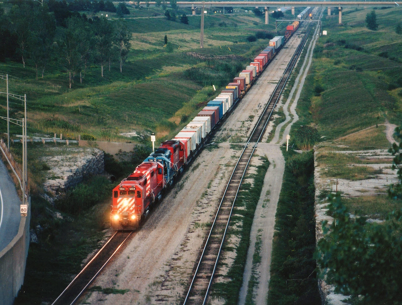 It is getting late and the light is getting weak as I waited out this daily Buffalo-Toronto train from a spot up and over the shared auto/railroad tunnel under the Welland Canal.  I had high hopes of bagging something I had not yet done, which was CP passing CN. But, alas, I failed. A couple of minutes later along came two CN switchers and a handful of cars going the opposite direction.(Note the lit signal in the distance). Still, CP 5914, 56xx, GATX 7368 and CP 5420 made for an interesting view. That is/was Hwy 58A on the left.
