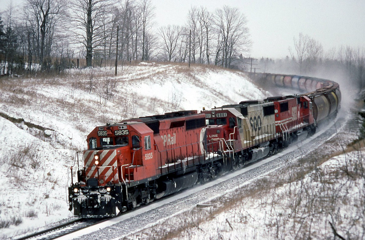 CP 5835 with train 301 in hand at track speed rounding the curves at Ajax, just about to duck under the old wooden bridge at Salem road. Train 301 is an empty grain returning west for another load of the good stuff beer is made from. The east bound loads would be headed to Quebec city for unloading.