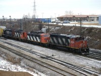 CN train 318. Always a prize catch in its day. On this dull over cast morning 318 would not let rail fans down.Switching its train at the east end of Oshawa yard a GP40-2W, A covered wagon all decked out for plow service, a GP9 with flexi coil trucks and a standard cab GP40 entering its last few months of service. Not to be past up.
