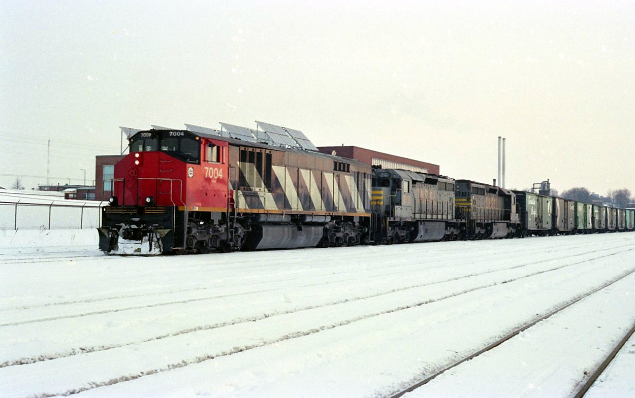 The winter of 1983-84, BBD test unit 7004 teams up with leased QNS&L SD40,s WB at CP Quebec Street, London. Can any body help with train number and a better date for this photo. All info has been erased with time on my sheets for this picture. The air tanks on the QNS&L units have been moved into the rear of the car body by the air compressor. Larger fuel capacity because of the remoteness of the Quebec North shore and the air tanks being located inside the car body had less chance of an air freeze up in the extreme temperatures in Quebec during winter.