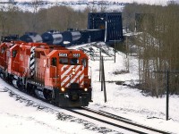 This is interesting. We have a relatively rare GP-35 leading the "Exshaw Turn" this day. Also, it is one of the very few trains operating shortly after this May snow storm. But what I think is the most notable aspect of the photo is the consist. The tank cars are separated by flat cars, suggesting that there is something contained in them that requires special handling - perhaps explosives for the quarrying at Exshaw?
There are several empty aggregate cars in behind the tank cars. 
Once again, I wish I had taken better notice of things back in 1986.