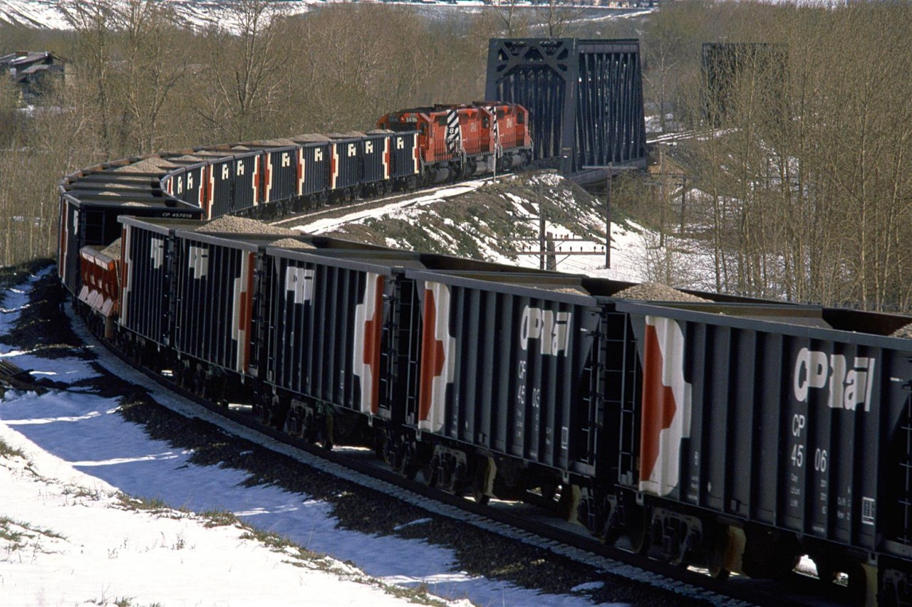 The first CP eastbound train through this area after a May snow storm. It picked up a string of gondolas full of aggregate from the Exshaw quarry/cement plant.
By now, the temperature had risen and the sun was out, resulting in significant snow melt.