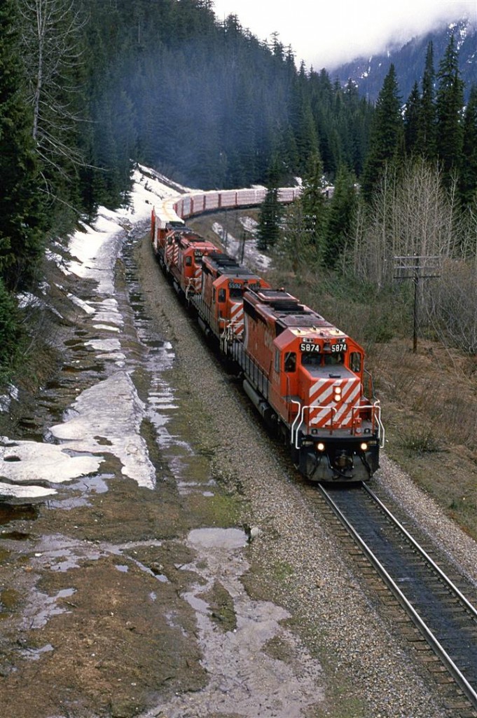 At the height of the Selkirk Mountains and Rogers Pass, this eastbound manifest is a couple kilometers from entering the Connaught Tunnel. The MacDonald Tunnel is under construction at this time.
