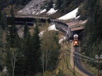 
I have always been enamored with snow sheds - even more so than with tunnels. In deep dark Illecillewaet (I had to look that up) Canyon, there is a rather photogenic one. This westbound manifest dissipates heat from the locomotive's dynamic brake blisters as it reins in the 100 cars pushing on them.