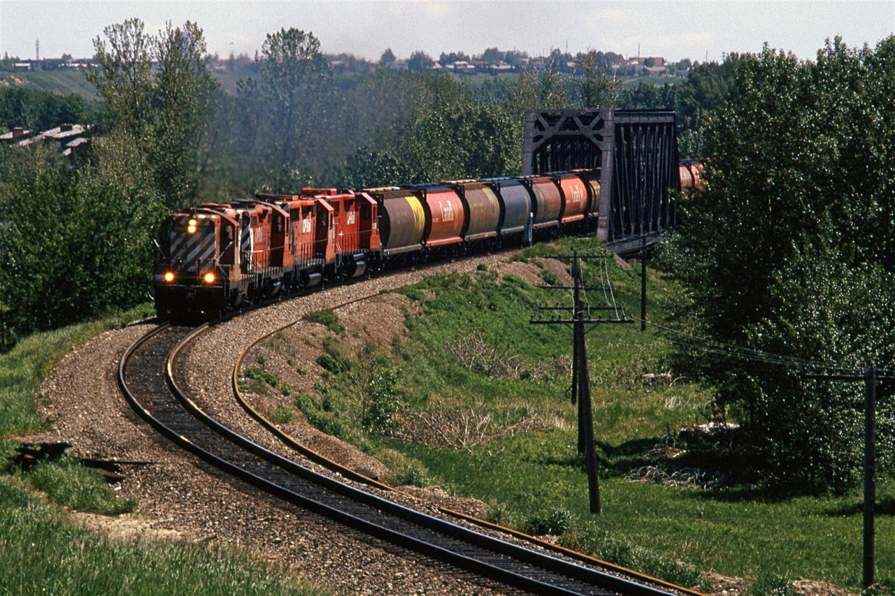 Another shot of the "Exshaw Turn" crossing the Bow River in west Calgary.
The grain hoppers will likely be dropped off at Kieth yard, since there are no grain handling facilities on the Laggan Sub.
The High-nose GP-9 was a treat to catch on this train. I would see them periodically in the yard, but they didn not seem to show up in front of my lens very often.