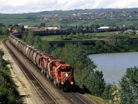 Eastbound potash and grain hopper train at Brickburn. There is a lot more sprawl on those hills in the background these days.