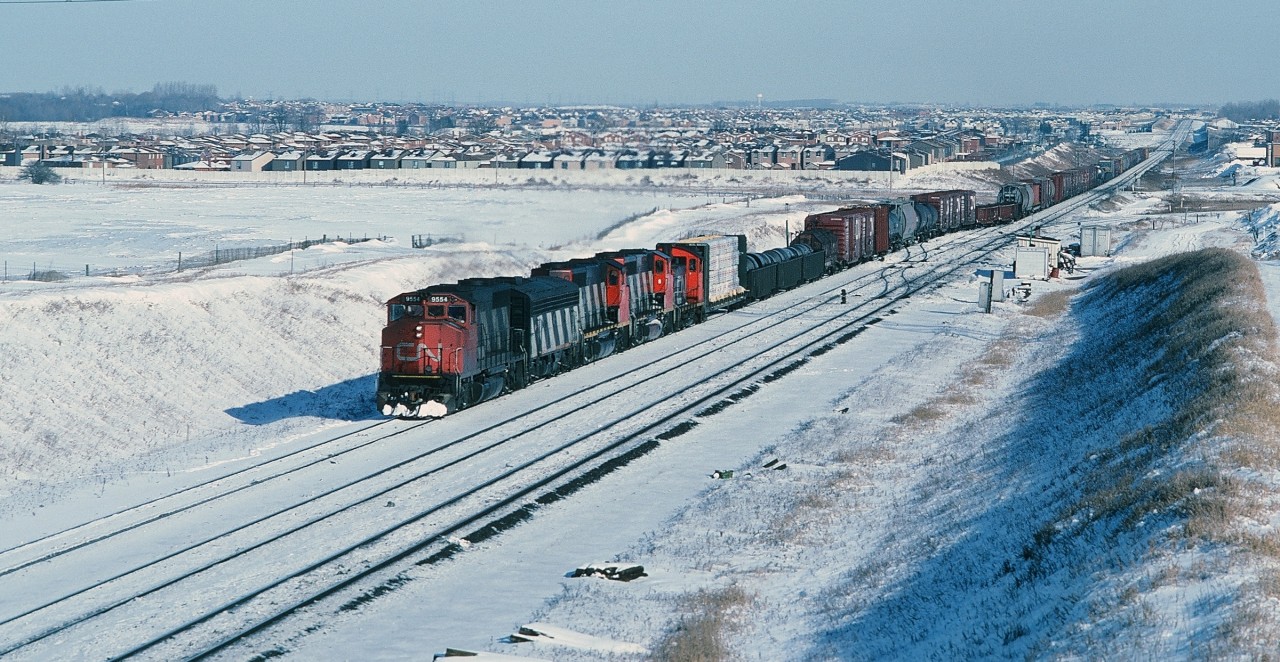 On a very cold January Saturday my trusty '79 Pontiac wagon  ( The  Parisienne – Atlantica ) found its way to CN Snider, where to no surprise a westbound typical  mixed freight with mixed power – some what unusual given GMD only – is occupying  the turnout to enter the Mac Yard lead.


CN 9554  ( GMD 1975 built GP40-2L(W) ) is teamed with a venerable F7Bu ( GMD 1951; rebuilt 1972 to 'u' status) and two other GP40's. The trailing SW may have been lifted at Oshawa along with the coiled steel gondolas – perhaps from Lasco Steel ( now Gerdau ).


All thirty of  the  CN rebuilt  (1972 ) F7's will be retired by 1989.


What's interesting: 1985: 


The year of the Polar Vortex ( yes, that term is not new ! )


The final chapter of the CAR begins:


 April 30 - CN and CP take over the Canada Southern (Michigan Central/New York Central/Penn Central/Conrail) line(s) through southern Ontario. 


more York Subdivision:


 MLW#2035  


 BBD#2118  


 BBD#2111  


and surprise, new owner:


  the repainted 9554 today  


sdfourty