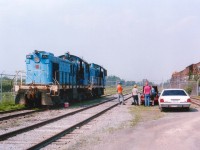 I was sitting at home one hot summer night, minding my own business (I think), and I get this phone call. The "boys" from the Leatherstocking Chapter of the National Railway Historical Society had made it to Welland from Oneonta, NY in quest of a couple of locomotives for the society's tourist train. So, being a member, I am obliged to help out, or at least greet them upon arrival :o). And off I go down to the former Intermetco factory just off the Hwy 406 by the canal. I brought a cooler of water and some other interesting thirst quenchers. It was HOT. So, after a sequence of photos both for myself, for the lads, and the Chapter Newsletter; we got to cleaning out these neglected units.
Slater Steel had purchased Atlas Specialty Steel recently and did away with the plant switchers. The two pictured are x-CN S-7 8223; now Atlas #10 and soon to be CACV 3152. Behind it is x-CN S-4 8181, now Atlas #9 and soon to be CACV 3151. CACV is Cooperstown and Charlotte Valley; the tourist road, owned by the LRHS, based out of Milford, NY.  First thing we stenciled the locomotives "CACX" on account we are not a common carrier railroad, so the reporting marks have to end in the letter "X"; thus making our official interchange reporting marks CACX. Before heading Stateside, both brake systems had to be updated in order to receive a current Blue Card, as required by the FRA. On July 4th Trillium S-13 #110 fetched the units to interchange with the CP for the trip to Cooperstown Jct., NY. They were a long time getting there, but currently both these units are still operating on the railroad. Cooperstown, for the Baseball Hall of Fame, is a great place to visit, and now you know there is a train ride to be had as well. The white car pictured is mine. I actually forgot how I got in there. :o)