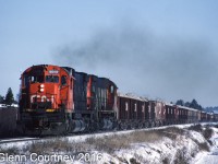 A Christmas visit back to Nova Scotia let me get out and shoot some of the weekday-only action that I rarely shot when I lived there. The main goal was the gypsum trains that ran between the quarry at Milford and the shipping pier at Wright's Cove. In 1987 you could chase and intercept the train a couple times in the 30-some miles between the quarry and Wright's Cove, not too likely you could do that today. 

Here's the loaded train with the typical locomotive consist of a pair of big MLWs trailing about 50 cars and van rolling between Elmsdale and Endfield. 