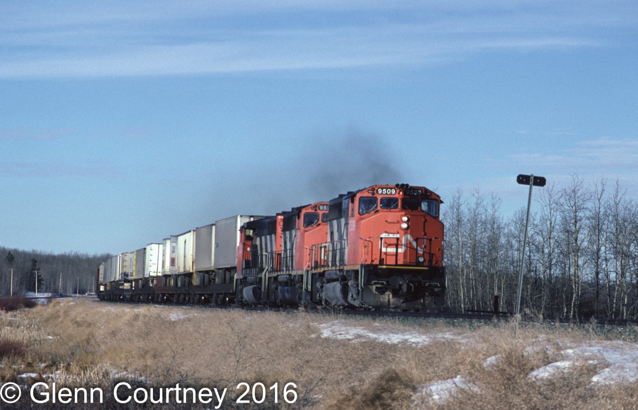 The immediate area east of Edmonton is relatively featureless scrub land that let eastbound trains roll along at track speed. And the roads don't always parellel the CN so chasing can be a challenge. Here's a trio of GP40-2s rolling an eastbound speed through North Cooking Lake.