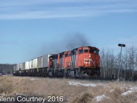 The immediate area east of Edmonton is relatively featureless scrub land that let eastbound trains roll along at track speed. And the roads don't always parellel the CN so chasing can be a challenge. Here's a trio of GP40-2s rolling an eastbound speed through North Cooking Lake. 