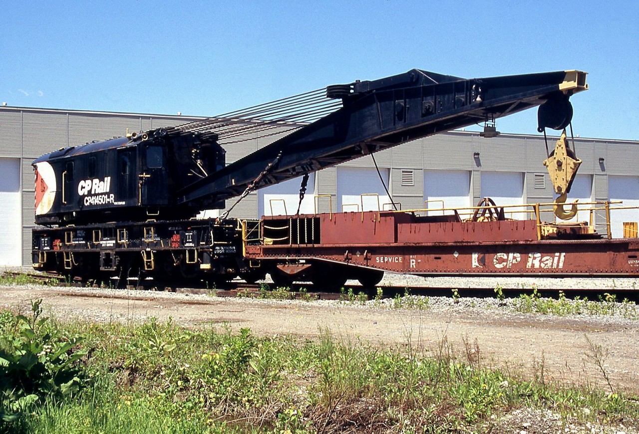 CP Rail "Big Hook" 414501, a 250-ton Industrial Brownhoist wrecking crane built in 1946 (originally steam powered, converted to diesel), sits at the Canadian Railway Museum (Exporail) with its boom car 412333.

Before the days of on-demand cleanup contractors like Hulcher and their fleets of side-boom Cat tractors, railways maintained their own wreck auxiliary trains at major divisions, that included a crane or two. Unlike the common small diesel-powered cranes commonly used for maintenance of way and track duties, wrecking cranes were intended for lifting and clearing heavy steam and later diesel locomotives to get the railway's line open again. Crane sizes varied: steam-powered-100 ton cranes built in the 1910/1920's were once common at smaller points during the steam era, and CP also rostered nearly a dozen large 200-ton cranes, but major terminals like Toronto would often warrant the biggest of the big: the 250-ton crane, of which CP owned about half a dozen in the 414500/414600 series.

Over time as contracting services became more popular, railways eliminated their auxiliaries and disposed of (scrapped) their large wrecking cranes, although CP does still maintain some out west in places like Golden and Revelstoke.

Based out of Toronto and the eastern region for much of its life, 414501 was put up for sale by CP in 2000, and acquired by Exporail in 2002.