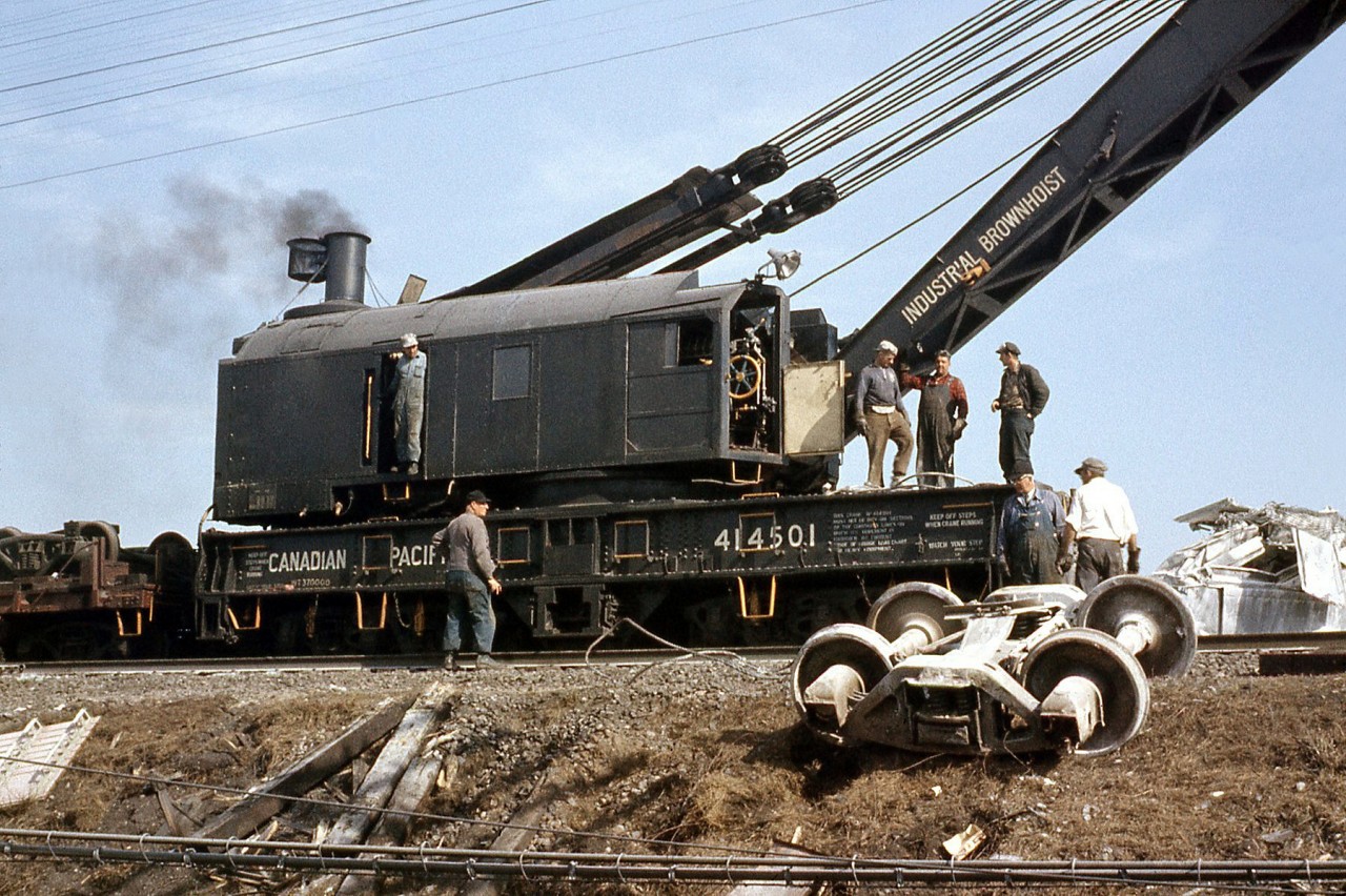 Another photo of Canadian Pacific "Big Hook" 414501 (an Industrial Brownhoist 250 ton wrecking crane, at time of this photo still steam powered!) working at a wreck at Dixie on the CP's Galt Subdivision in 1959. It was quite pile up of cars (no locos) mainly from the Kitchener/Waterloo and Galt areas, including beer and whiskey in box cars (from Seagrams & Carlings in Waterloo) and a lot of limestone from covered hoppers. What was unusual was the lack of security - just one railway policeman in uniform. When I approached to take photos he came up to me and said be careful, also do not take any booze. Note workers on crane - very casual, no hard hats, etc. A diferent era compared to today.

CP 414501 after retirement at Exporail: http://www.railpictures.ca/?attachment_id=23098