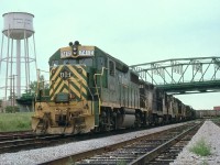 I uploaded an image of this train quite a while back; however, this angle, showing the old Niagara water tower and the Central Av bridge also shows a lot more of the train. Norfolk & Western was involved in a contract dispute that dragged on for a year and a half before a strike was called by the Brotherhood of Railway and Airline Clerks (BRAC). Pickets succeeded in slowing down operations, but the real damage was when secondary pickets disrupted operations of connecting roads. The strike spread, and eventually a month after this photo was taken, over 350,000 employees nation-wide were off the job. The government had to step in. Unfortunately for me, I had planned a cross-USA trip that year. So I remember the Great Strike of 1978. The only trains I saw moving the whole trip were probably operated by non-union company officials and the like. This train, avoiding hassles, crossed Sou Ontario via the CASO. Power is D&H 7412, N&W 830, 2493, D&H 7420, N&W 2709,xxxx, and 1572.
