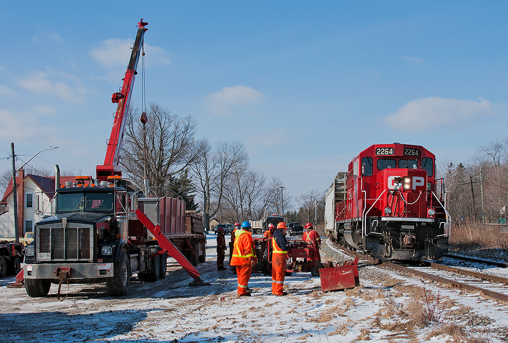 A special transformer move arrives at Myrtle where crews from Don Anderson Haulage and Ontario Hydro will begin to set up. The move will take this transformer load off it's center depressed flat car onto a heavy duty center depressed tractor trailer for further delivery to a substation up street.