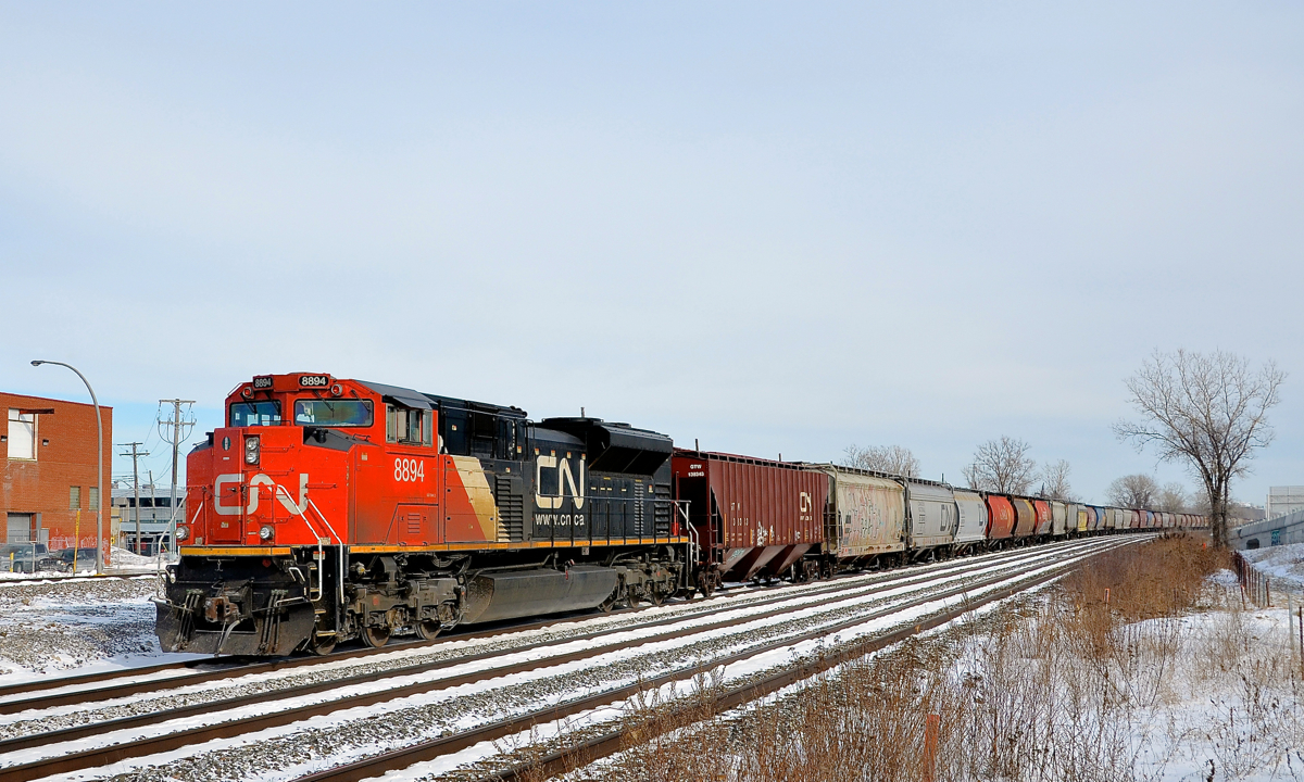 Shoving on a monster grain train. CN 8894 shoves on 136 loaded grain cars as a very lengthy CN 874 makes its way through Dorval. Up front are CN 2318 & IC 1028.