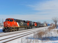 <b>White snow and blue skies.</b> The day after a storm dropped 15 cm of snow on Montreal, covered it with rain and then froze it, the sky is blue and the frozen snow really makes everything brighter as a very late CN 369 heads west through Dorval with CN 2816 & CN 3017 at the head end. Operating mid-train is CN 3018
