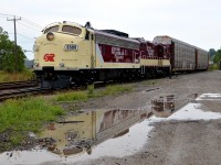 <b>F-unit reflected in the rain.</b> FP9A OSRX 6508 and GP9 OSRX 1620 are parked at Woodstock, with the units reflected in the rain.